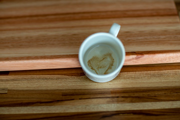 A Cup of Coffee with Heart Inside the Cup brown Wooden Background. 