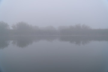 Fototapeta premium Mystical Fog in the early morning on a small lake