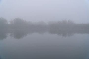 Obraz na płótnie Canvas Mystical Fog in the early morning on a small lake