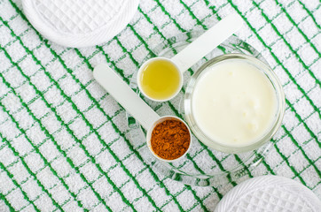 Greek yogurt (sour cream or kefir) facial mask with turmeric powder and olive oil. Ingredients of diy face and hair masks and moisturizers. Homemade beauty treatments recipe. Top view, copy space 