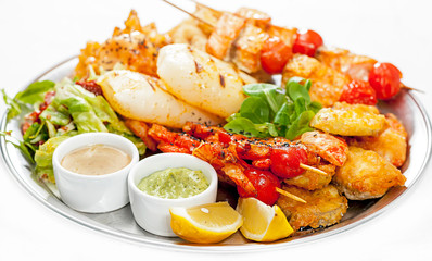 A plate with meat dishes, kebabs, bishtex, sauces and various croutons.
