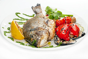 Fried tilampia on a dish with vegetables.