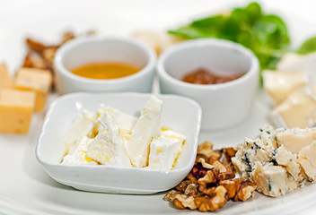 Dish with different types of cheese and sauces. Cheese torte with sauces.