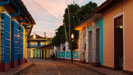 old cobblestone street in Trinidad with colorful houses at sunset