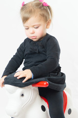 The little girl child riding Toy horse