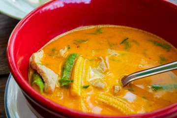 Thai yellow curry soup with rice on rustic table