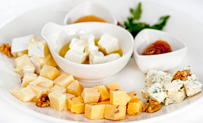 Dish with different types of cheese and sauces. Cheese torte with sauces.