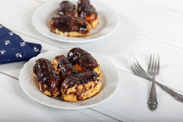 Ekler Pasta / Chocolate Donut in plate on white background.