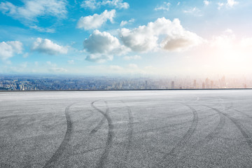 Fototapeta premium Shanghai city skyline and asphalt race track ground at sunrise,high angle view
