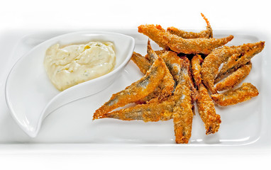 Fried capelin with sauce on a plate.