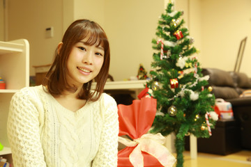 クリスマスツリーの飾りをつける女性