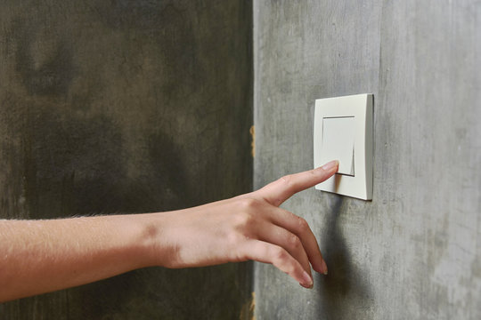 Female hand, to turn off the light, switch, front view