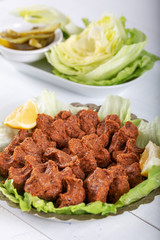 Turkish Food Cig Kofte with lemon, lettuce and parsley on silver plate