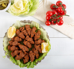 Turkish Food Cig Kofte with lemon, lettuce and parsley on silver plate