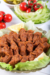 Turkish Food Cig Kofte with lemon, lettuce and parsley on silver plate