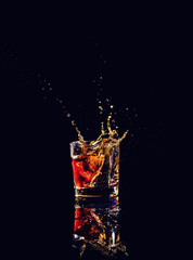 shot of whiskey with splash on black background