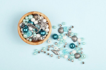 A set of beads for making necklaces. Varied shape, blue background