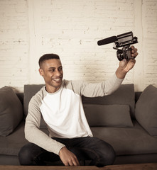 Young happy blogger recording video on camera for internet blog