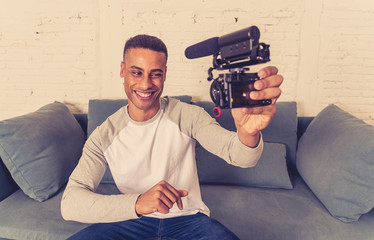 Young happy blogger recording video on camera for internet blog