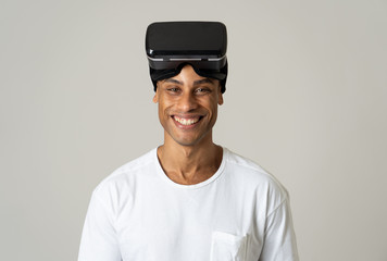 Portrait of cheerful young man wearing Virtual Reality goggles for first time smiling at camera