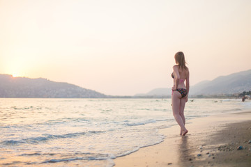 Summer woman bikini vacations concept. Outdoor lifestyle portrait of beautiful girl in swimsuit. Happy Carefree Woman Enjoying Beautiful Sunset on the Beach