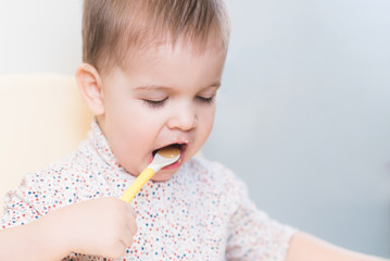 the kid in the kitchen eats milk porridge