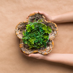 Gardener taking unusual pot with artificial plant