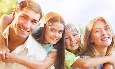 Parents Giving Children Piggybacks In Countryside