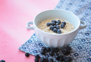 Oatmeal porridge with blueberry, blackberries and currants for breakfast