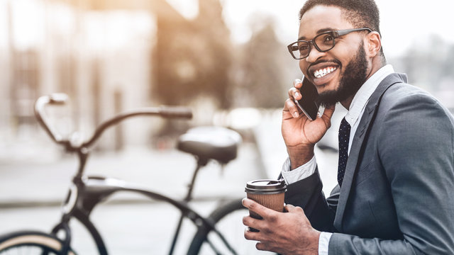 Smiling businessman talking on phone sitting outdoors