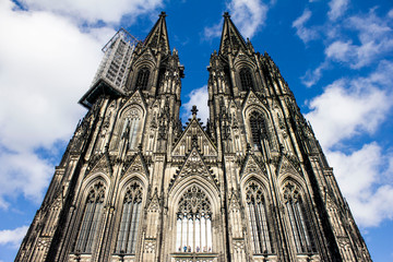 Fototapeta na wymiar Mighty huge and high Cologne Dome in the blue sky. Famous German ancient cathedral in the center of Cologne.