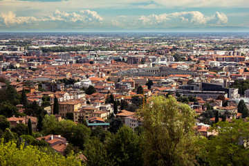 Fototapeta na wymiar Beautiful plain brown roofs panorama of the Italian Bergamo city. View from the upper side of Bergamo (from old town). Building roofs, cityscape and skyline.
