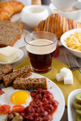 Mug of coffee on the table with English breakfast and croissant