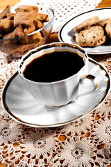 A cup of coffee, lace doily, wooden table, rustic style. Selective focus