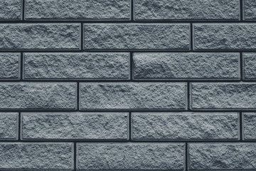 Naklejka premium Texture of gray brick wall. The wall is tiled decorative. Grey stone background of house facade. Brick wall texture grunge background.