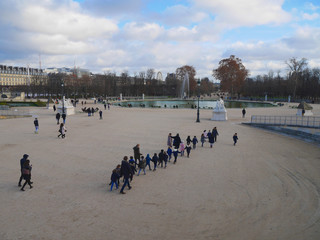 Obraz premium Paris 20 December 2018. Tuileries park. There is a group of children with a teacher. Tourists go. bright day