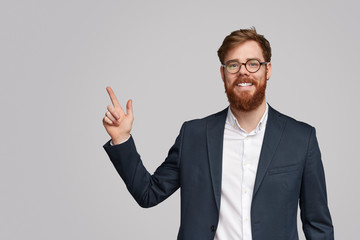 Friendly businessman pointing at empty space