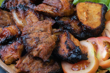 close up of grilled pork on wooden plate