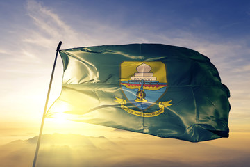 Jambi province of Indonesia flag waving on the top sunrise mist fog