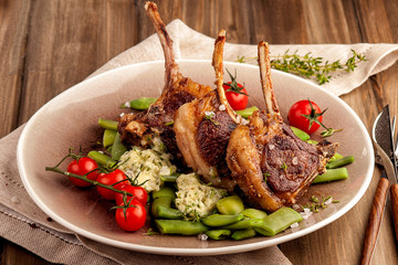 Grilled lamb chops with a garnish of green beans and fragrant butter. With tomatoes and fresh thyme. Homemade cooked dish. Ketogenic food.  Close up horizontal view.