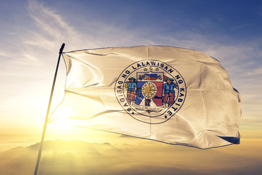 Cavite province of Philippines flag waving on the top sunrise mist fog