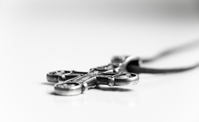 church silver cross lies on the table. Isolated on white background