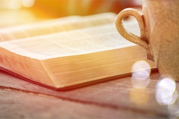 Open book on old wooden table.