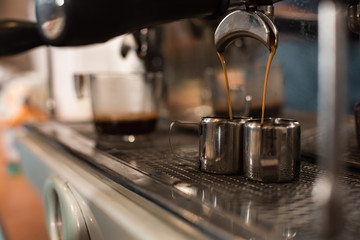 Selective focus of coffee machine and two stainless cups