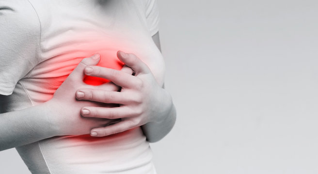 Woman suffering from painful feelings, clutching her boob