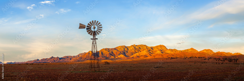 Wall mural a windmill with the flinders ranges behind it in the australian outback. flinders ranges national pa