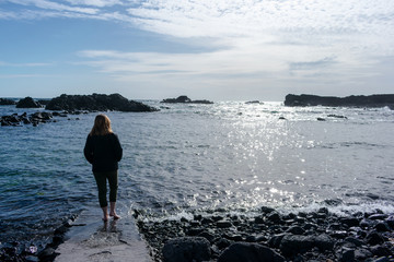 Young woman in the beach. She is playing with the water.
