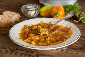 Plate of borsch on a wooden table (Ukrainian food)