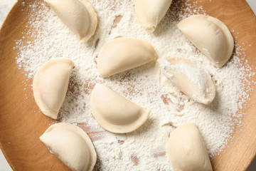 Fototapeta na wymiar Closeup of plate with raw dumplings, top view. Home cooking