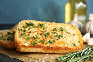 Tasty garlic bread with herbs on table